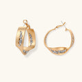 Sculptural wavy hoop earrings with crystal details and organic curved silhouette in gold and silver variants